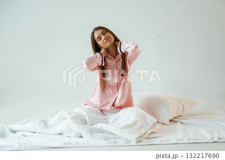 Rest conception, waking up, on the white blanket. Young pretty woman is against background in the studio 132217690