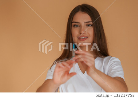 Vaccination concept, nurse is with syringe. Young pretty woman is against background in the studio Vaccination concept, nurse is with syringe. Young pretty woman is against background in the studio 132217758
