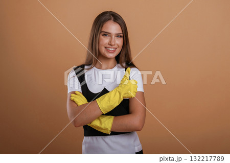 Against background, chambermaid at work. Young pretty woman is in the studio Against background, chambermaid at work. Young pretty woman is in the studio 132217789