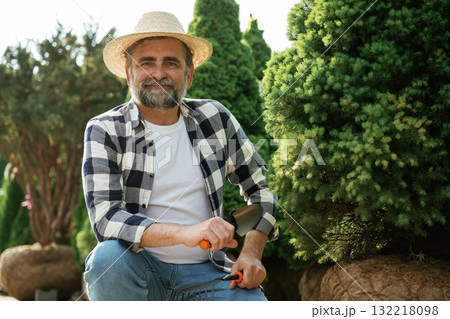 Beautiful portrait. Senior gardener is at work at daytime Beautiful portrait. Senior gardener is at work at daytime 132218098