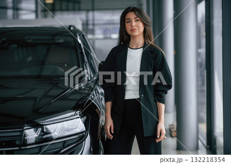 Saleswoman in car showroom, selling automobile 132218354