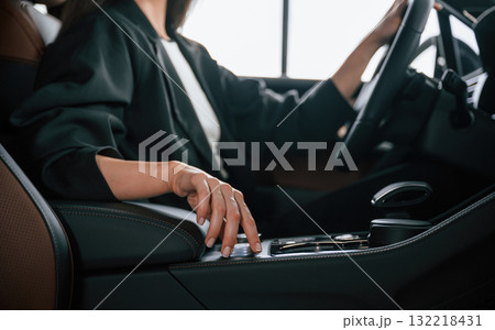Turning the knob. Beautiful businesswoman is in the new car Turning the knob. Beautiful businesswoman is in the new car 132218431