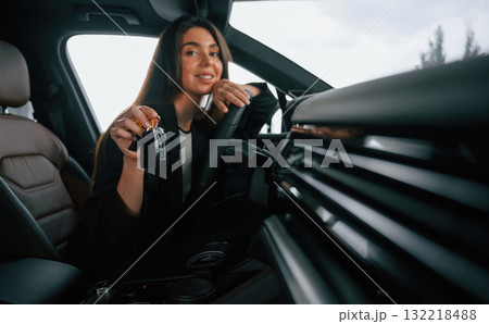 Cheerful, happy new owner with keys. Beautiful businesswoman is in the new car Cheerful, happy new owner with keys. Beautiful businesswoman is in the new car 132218488