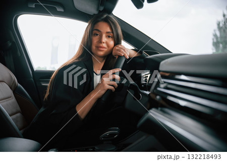 Leaning on the steering wheel. Beautiful businesswoman is in the new car Leaning on the steering wheel. Beautiful businesswoman is in the new car 132218493