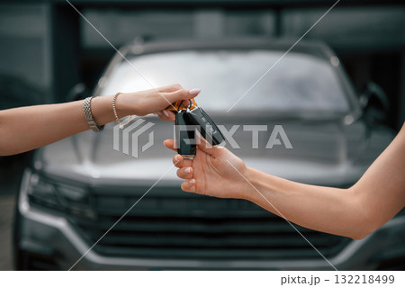 Order is finished. Woman hands are giving and taking the keys for the new automobile 132218499