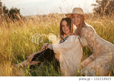 Sitting together. Two women friends are in the rural field 132218925