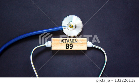 Vitamin B9 folic acid symbol. Concept words Vitamin B9 on beautiful wooden block. Stethoscope. Beautiful black background. Medical healthy lifestyle Vitamin B9 concept. Vitamin B9 folic acid symbol. Concept words Vitamin B9 on beautiful wooden block. Stethoscope. Beautiful black background. Medical healthy lifestyle Vitamin B9 concept. 132220118