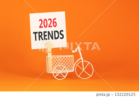 2026 Trends symbol. Concept words 2026 Trends on beautiful white paper on wooden clothespin. Beautiful orange background. Beautiful miniature bicycle. Business 2026 Trends new year concept. Copy space 132220125