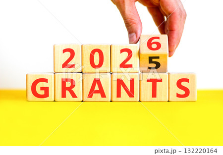 2026 Grants symbol. Concept words 2026 Grants on beautiful wooden blocks. Beautiful white and yellow paper background. Businessman's hand. Business and 2026 grants concept. Copy space. 132220164