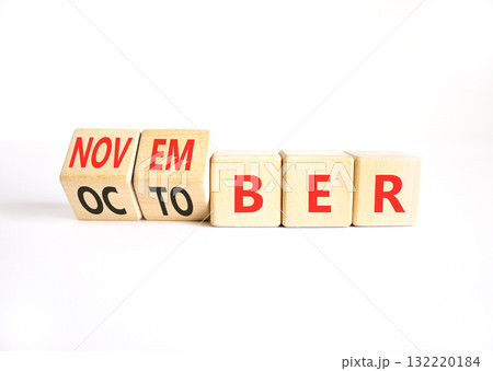 Symbol for the change from October to November. Businessman turns wooden cubes and changes the word October to November. Beautiful white background. Happy November concept. Copy space. 132220184