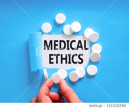 Medical ethics symbol. Concept words Medical ethics on beautiful white paper. White pills tablets. Doctor's hand. Beautiful blue background. Medical healthy lifestyle medical ethics concept. Medical ethics symbol. Concept words Medical ethics on beautiful white paper. White pills tablets. Doctor's hand. Beautiful blue background. Medical healthy lifestyle medical ethics concept. 132220298