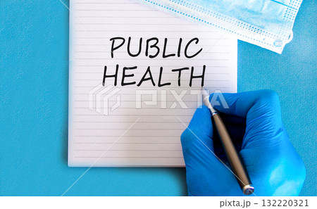 Public health symbol. Concept words Public health on beautiful white note. Doctor's hand in blue medical glove. Medical mask. Beautiful blue background. Medical healthy lifestyle public health concept 132220321