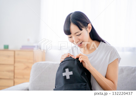 防災リュックを持つ若い女性 132220437