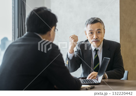 会議でガッツポーズをするシニアビジネスマン 132220442