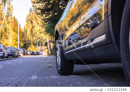 Reflections and autumn colors captured along a quiet street with parked cars Reflections and autumn colors captured along a quiet street with parked cars 132221348