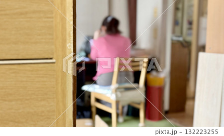 隣の部屋で机に向かう女性の後姿 隣の部屋で机に向かう女性の後姿 132223255