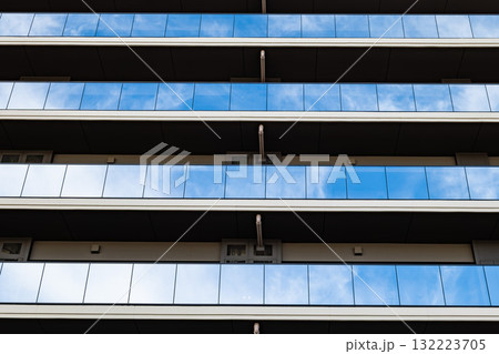 反射するガラスと整然としたラインが美しい現代マンション外観 132223705