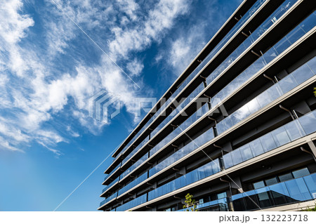 洗練されたガラス手すりの高層マンションと青空が織りなす現代建築の美 洗練されたガラス手すりの高層マンションと青空が織りなす現代建築の美 132223718