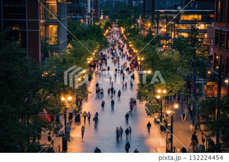 Busy Urban Street with Pedestrians in Evening Light Surrounded by Trees and Buildings Busy Urban Street with Pedestrians in Evening Light Surrounded by Trees and Buildings 132224454