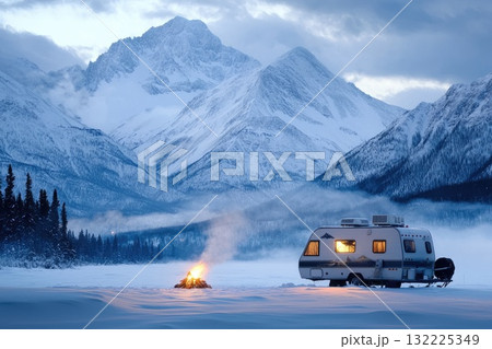 Serene Winter Camping Scene with a Camper and Campfire in a Snowy Landscape Surrounded by Majestic Mountains Under a Dramatic Sky at Dusk Serene Winter Camping Scene with a Camper and Campfire in a Snowy Landscape Surrounded by Majestic Mountains Under a Dramatic Sky at Dusk 132225349