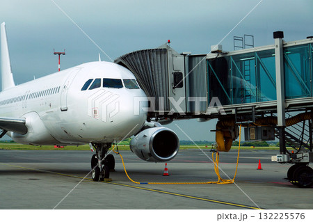 Charter airline airplane preparing for flight on airport runway with connected jet boarding bridge Charter airline airplane preparing for flight on airport runway with connected jet boarding bridge 132225576