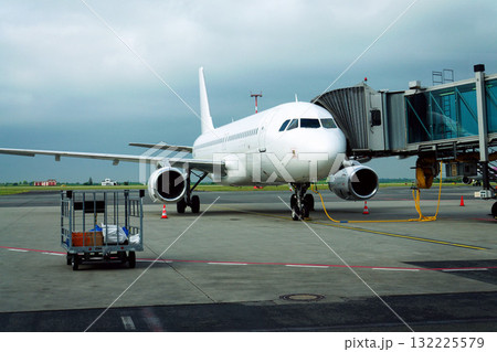 Charter airline airplane preparing for flight on airport runway with connected jet boarding bridge Charter airline airplane preparing for flight on airport runway with connected jet boarding bridge 132225579