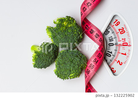 Broccoli with measuring tape on weight scale. Dieting 132225902