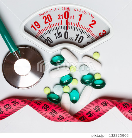 Pills stethoscope measuring tape on scales. Health care Pills stethoscope measuring tape on scales. Health care 132225903