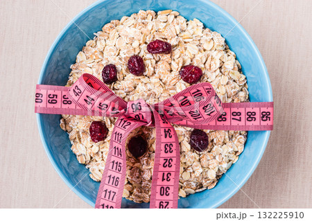 Oatmeal in blue bowl with measuring tape around Oatmeal in blue bowl with measuring tape around 132225910