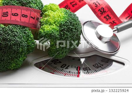 Broccoli with measuring tape on weight scale. Dieting Broccoli with measuring tape on weight scale. Dieting 132225924