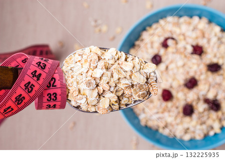 Oatmeal in bowl and measuring tape around spoon 132225935