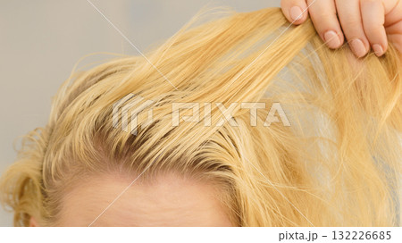Blonde woman having greasy hair Blonde woman having greasy hair 132226685