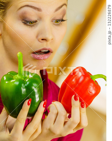 Woman holding bell peppers paprika thinking Woman holding bell peppers paprika thinking 132226879
