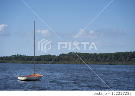 Sailboat on Lac de Leon in the Landes department on a sunny day Sailboat on Lac de Leon in the Landes department on a sunny day 132227283