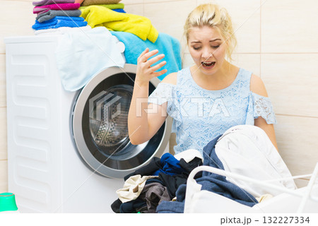 Unhappy woman having a lot of laundry Unhappy woman having a lot of laundry 132227334
