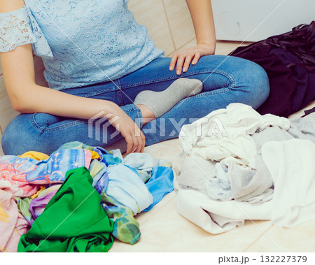 Woman sorting clothes for washing 132227379