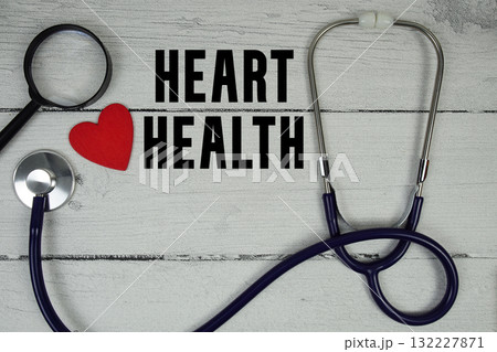 Heart Health text with Red heart, Magnifying glass and Medical Stethoscope on wooden background 132227871