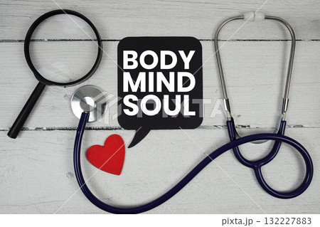 Body Mind Soul text with Red heart, Magnifying glass and Medical Stethoscope on wooden background 132227883