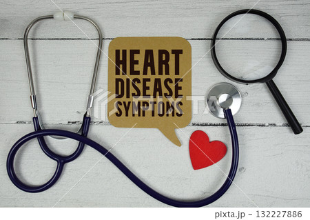 Heart Disease Symptoms text with Red heart, Magnifying glass and Medical Stethoscope on wooden background Heart Disease Symptoms text with Red heart, Magnifying glass and Medical Stethoscope on wooden background 132227886