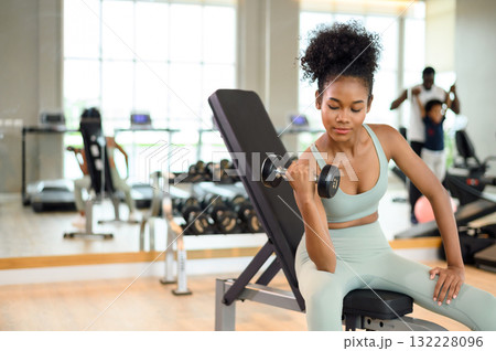 Sporty fitness African American woman working out with dumbbells strength and strength endurance at the gym. Sporty fitness African American woman working out with dumbbells strength and strength endurance at the gym. 132228096