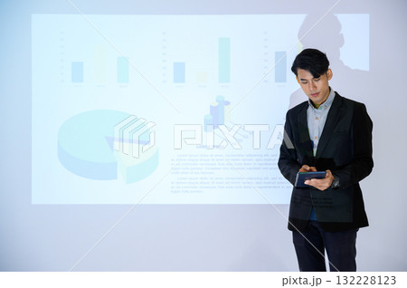 Business man gives presentation to colleagues during meeting, Shows Infographics Animation on Big Screen. 132228123