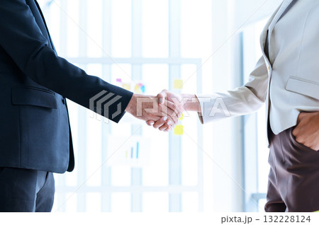 closeup of business partners shaking hands after concluding a business finished. Businessman and Businesswoman handshake in the meeting room. Business to succeed concept, Collaborative teamwork. 132228124