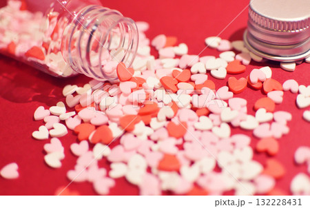 小瓶から零れるハート型のトッピングシュガー　かわいい背景装飾　溢れる気持ち　製菓材料 132228431