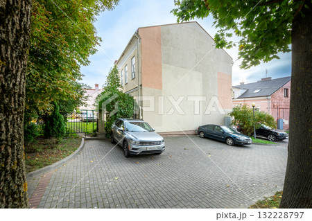 Cozy Courtyard with Parked Cars and Old Building 132228797
