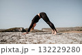 Woman Practicing Yoga in a Mountainous Landscape 132229280