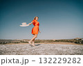 Woman in Orange Dress Enjoying the Sunny Day 132229282