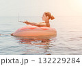 Woman Laptop Beach - A woman in a pink inflatable ring uses a laptop while floating in the ocean. 132229284