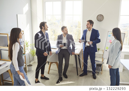 Young professionals discussing business strategies in office with man presenting ideas to colleagues Young professionals discussing business strategies in office with man presenting ideas to colleagues 132229293