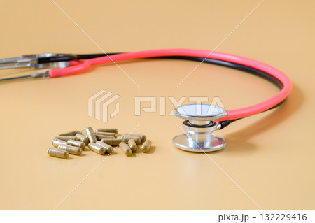 Duo stethoscopes with herb capsule on background. Duo stethoscopes with herb capsule on background. 132229416