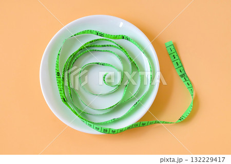 Green measuring tape on white dishwasher. Green measuring tape on white dishwasher. 132229417